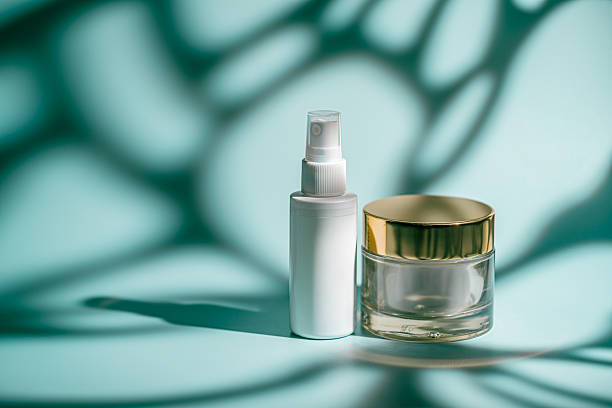istock Glass face serum and rich cream jar on blue 2228341691