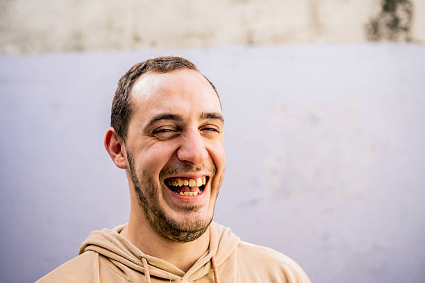 Portrait of a happy young man on a wall background