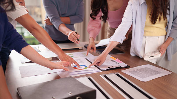 istock Business professionals collaborating on financial reports analyzing market data making strategic decisions in a modern office meeting room 2228350668