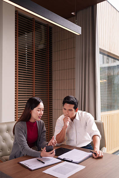 istock Asian adult business professionals discuss project strategy using smartphone documents in modern office meeting room collaboration thinking solutions 2228350681