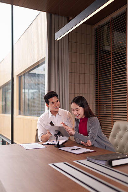istock Asian business professionals collaborating reviewing digital data using modern tablet technology engaging discussions contemporary office meeting room productive work environment 2228350693