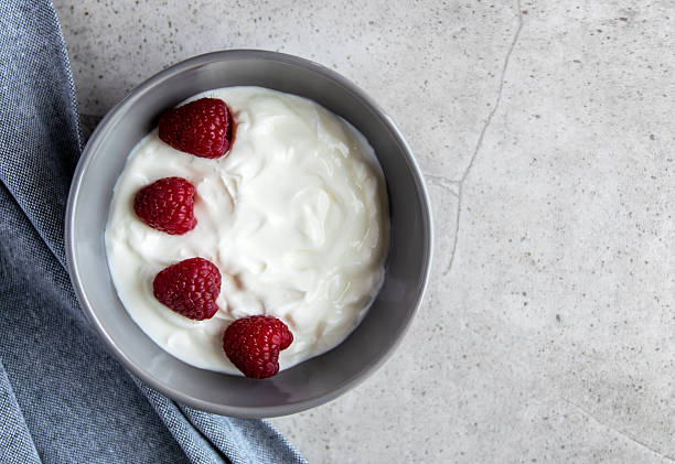 istock Gray bowl and natural yogurt with berries on the stone marble table. 2228351632