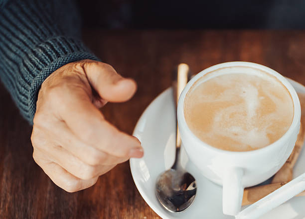 istock An elderly woman drinks hot coffee, hand and a cup closeup. 2228352951