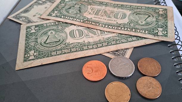 istock Dollar bills and coins on top of a school notebook 2228355617