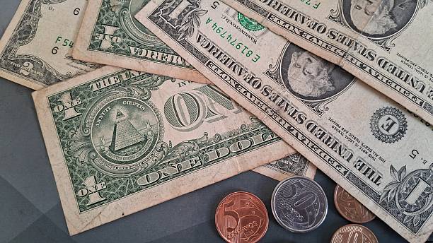 istock Dollar bills and coins on top of a school notebook 2228355640