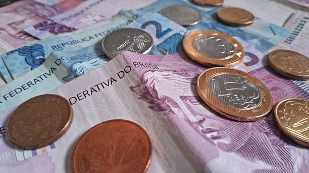 istock Coins on top of Brazilian real notes 2228361745
