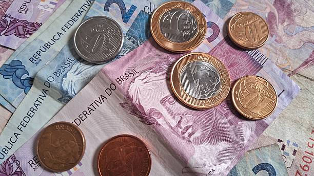 istock Coins on top of Brazilian real notes 2228361759
