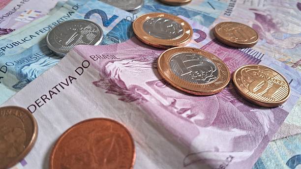 istock Coins on top of Brazilian real notes 2228361779
