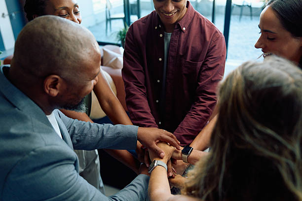istock Diverse business people smiling while putting their arms together in office 2228366105
