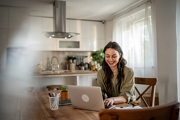 istock Young woman working from home on laptop and smiling 2228369680