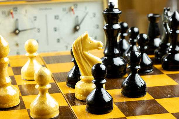 A close-up of a chessboard with black and white pieces.