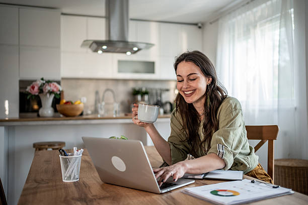 istock Young woman working remotely from home drinking coffee 2228373939