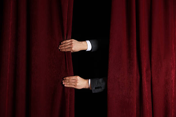 istock Man closing red front curtains in theatre, closeup 2228381534
