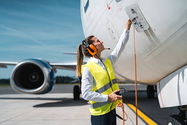 istock Caucasian Female Ramp Agent Plugging Headset into Aircraft Panel 2228383047