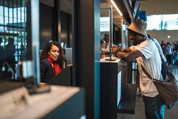 istock Young Hispanic Stewardess Engaging with Mid Adult Black Passenger at Check-In 2228383302