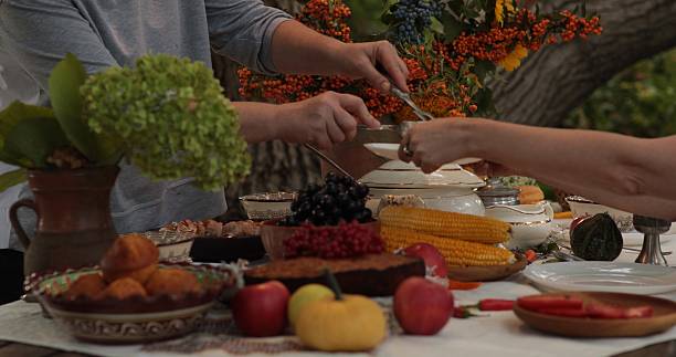 istock Thanksgiving dinner table filled with delicious food and joyful interactions between family members celebrating a warm autumn gathering outdoors amidst colorful decorations 2228383490