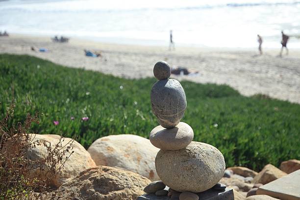 Zen stacking rocks on a Carlsbad, California beach.