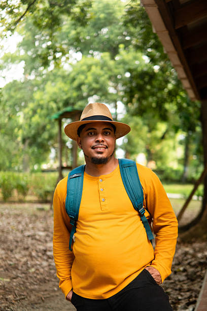 istock Young man with a backpack and hat finds peace while hiking through a lush green forest, connecting with nature for mental well-being 2228396965