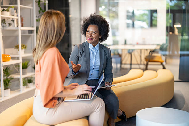 istock Two Women Engaging in Conversation in Stylish Office 2228400243