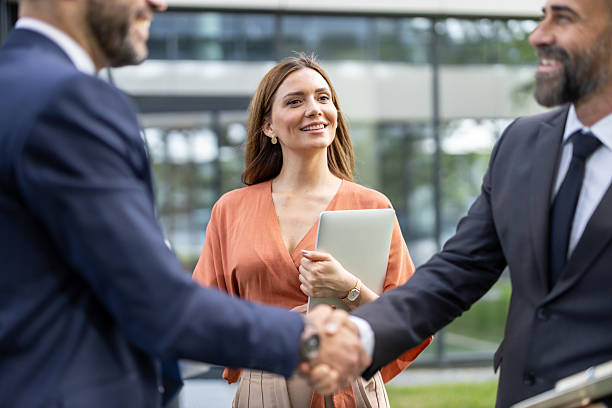 istock Professional handshake outdoors with smiling woman in focus 2228400272