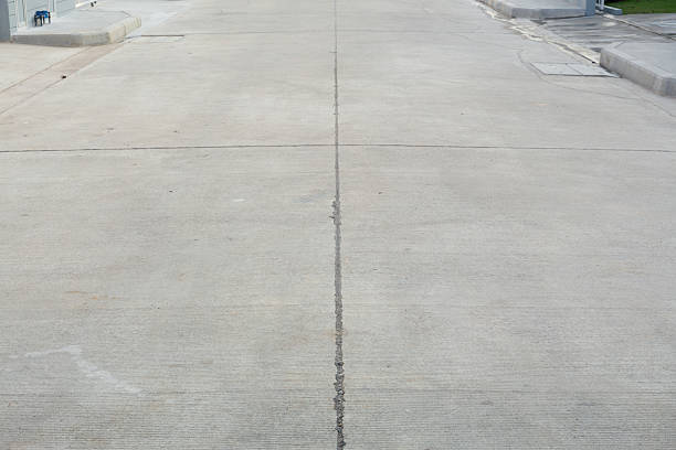 Perspective view of concrete pavement floor or road in residential village, expansion joints. Represents construction industry materials, infrastructure development and transportation surface.