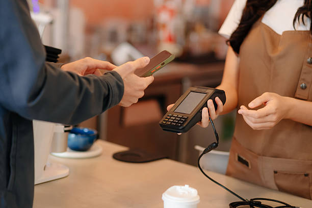 istock Barista facilitating a contactless payment using a card reader and smartphone. Capturing modern technology 2228410038