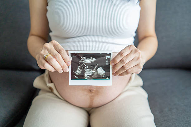 istock expecting woman holding sonogram 2228410326