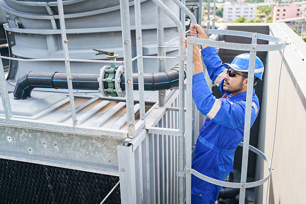 istock Technician climbs rooftop to fix HVAC and ventilation systems on a tall building. 2228410786