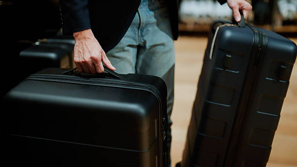 istock Man in suit choosing between two large suitcases before a business trip. 2228418737