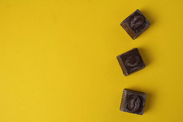 istock Chocolates lie on a yellow background with space for copyspace text. Background with chocolate 2228420125