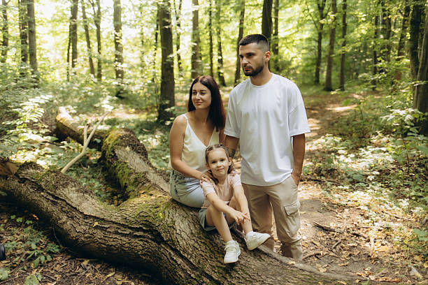 istock Family Posing Together in a Serene Forest During a Sunny Day 2228420705
