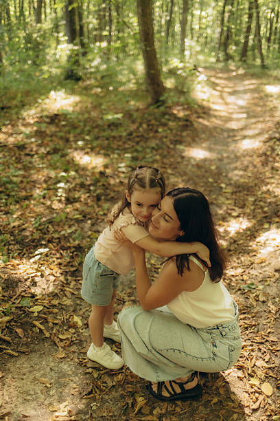 istock Mother and Daughter Hugging in a Serene Forest Setting 2228421021