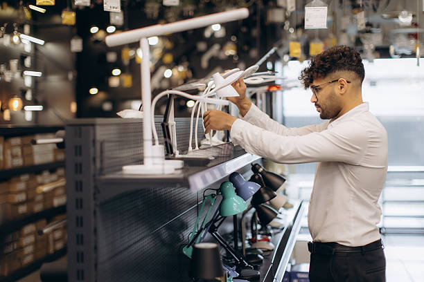 istock Man Browsing Desk Lamps in a Modern Lighting Store 2228422197