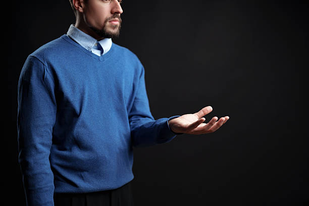 istock Man in blue sweater with open hand gestures in a studio setting during evening 2228423892