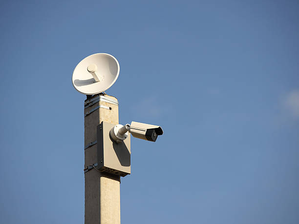 istock Surveillance system with an orange warning light located on a pole in the open. The threat of privacy and the protection of personal data. Security tracking on the streets of the city. Human mass 2228425842