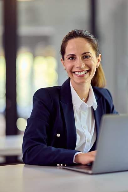 istock Professional Businesswoman Smiling While Working on a Laptop in a Modern Office 2228426426