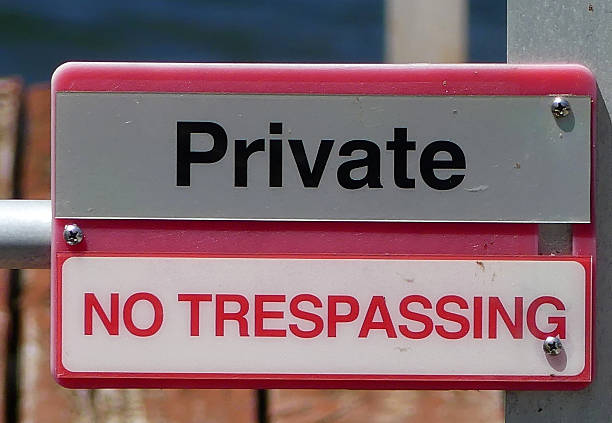 Private property sign seen at the automated entrance to a large, private gated community of luxury houses and apartments.