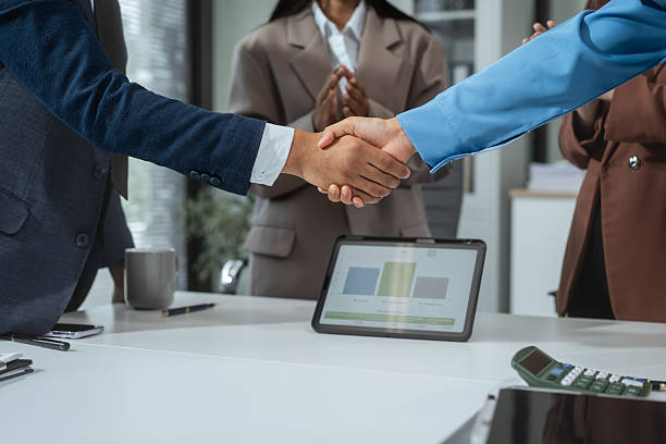 istock Business professionals shake hands at the table to conclude a successful agreement or collaboration. Cooperation, trust, investment, mutual success, which is the closing of a strategic business deal 2228429851