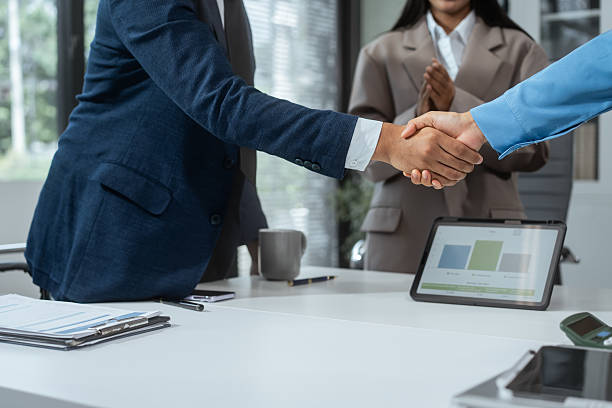 istock Business professionals shake hands at the table to conclude a successful agreement or collaboration. Cooperation, trust, investment, mutual success, which is the closing of a strategic business deal 2228429861