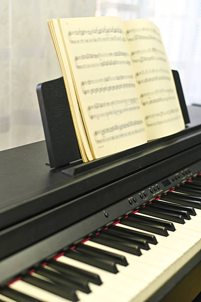 istock vertical photo music book standing on electronic piano, symbolizing creativity and practice. music book is vital tool for honing musical skills and creativity 2228433407