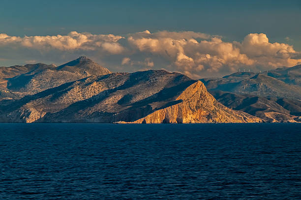 Golden evening sunset on cliff face from the sea, Crete, Greece.