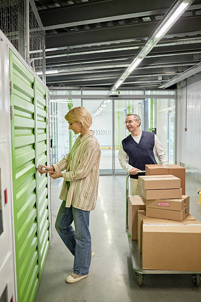 istock Middle Aged Woman Opening Locker While Caucasian Man Waiting 2228439930