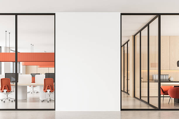 istock Modern open space office with red chairs and glass partitions featuring a blank central wall for design mockup or branding display concept. 3D Rendering 2228442271