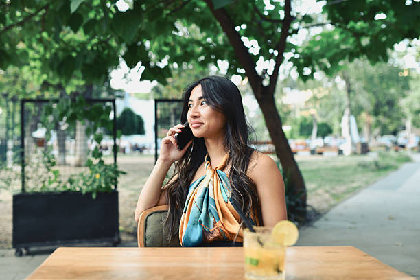 istock Smiling Female Enjoying Phone Conversation While Sitting At Coffee Bar With Cocktail 2228442431
