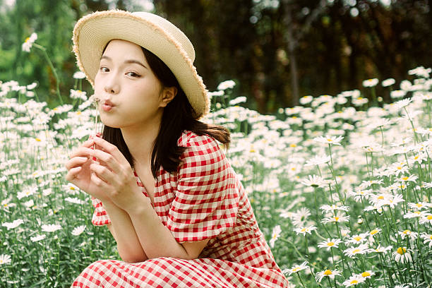 Young woman in pink plaid dress among flowers