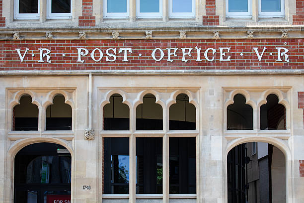 Close-up of a vintage Post Office sign on the exterior of a building located on Cornhill in the town of Bury St. Edmunds in Suffolk, UK.