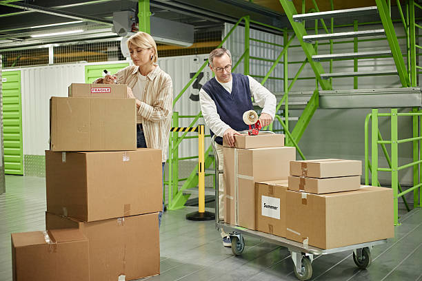istock Middle Aged Caucasian Man and Woman Packing Cardboard Boxes 2228445176