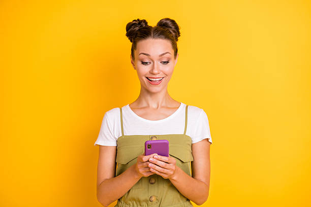 istock Portrait of attractive focused cheerful girl using gadget pastime browsing web isolated over bright yellow color background 2228447987