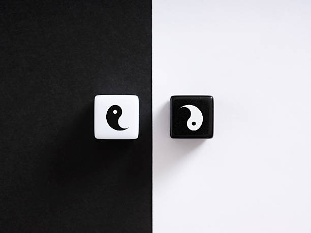 Two dice featuring the yin yang symbol represent the balance and harmony of opposing forces, embodying concepts of duality and unity