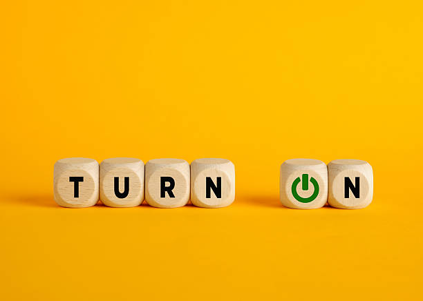 istock Wooden cubes composing the words turn on with a power button symbol on a yellow background 2228449988